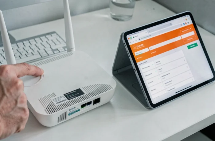 Gros plan sur une box Orange et une tablette affichant l'interface de changement du mot de passe WiFi